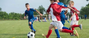 A bunch of kids playing football in the field